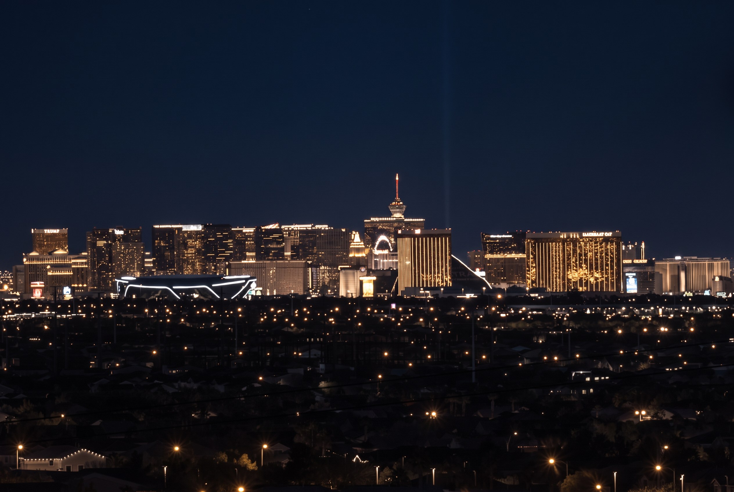 The Las Vegas Strip skyline glowing at night, seen across the valley from the city's west side