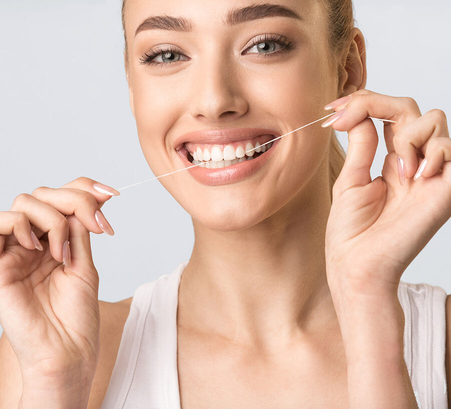Girl Using Floss Cleaning Teeth Standing Over Gray Background, Studio